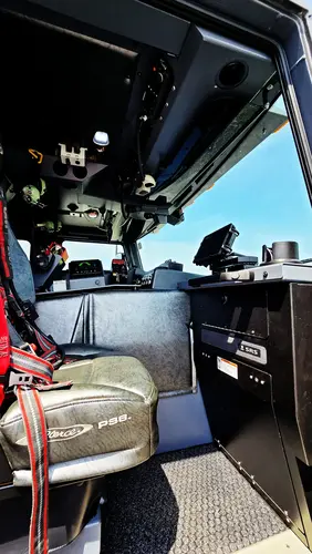 Cab interior side view showing front seat, dash mounts, and console