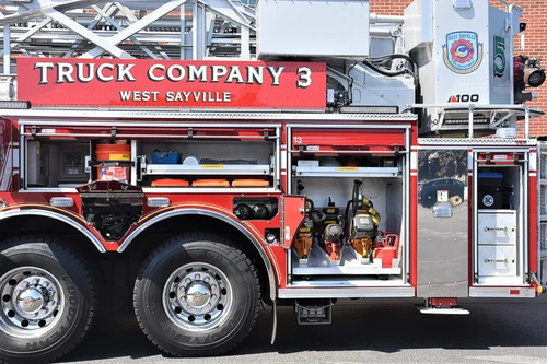 Driver-side mid-body view showing truck company lettering above tandem wheels