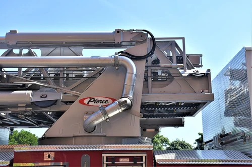 Ladder base close-up showing hydraulic piping and aerial support arms
