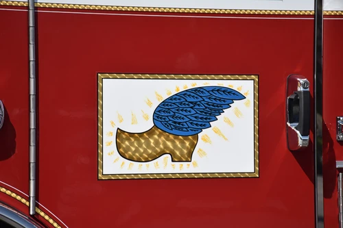 Cab door close-up showing winged-foot style emblem on red panel
