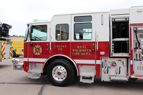 Driver-side profile view showing pump panel and open side compartment