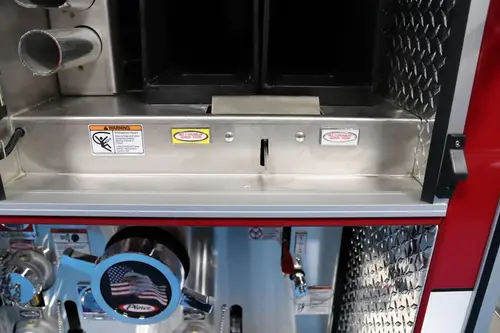 Lower compartment close-up showing intake plumbing and hose connection points