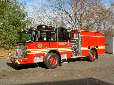 Front left exterior view showing cab, side pump panel, and long rear body compartments.