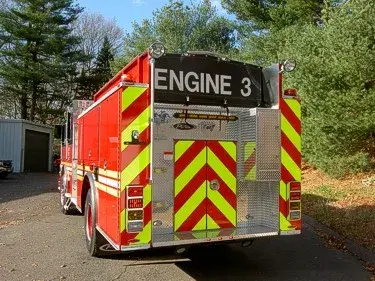 Rear right angle showing red-yellow chevrons, rear door panel, and tail light stack.