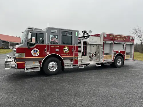 Officer-side exterior view showing open compartments, pump panel, and crew cab
