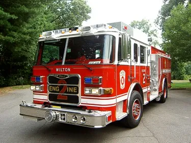 Pumper front-left exterior view showing enclosed cab, bumper, and side compartments