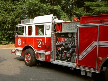 Driver-side profile view showing exposed pump panel, controls, and wheel area