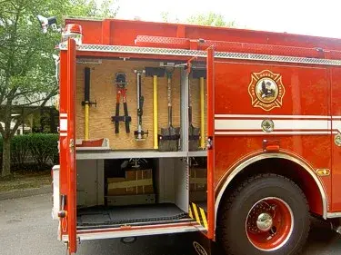 Open side compartment view showing long-handled tools and storage shelf