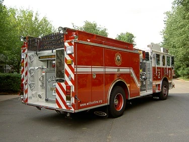 Rear-right exterior view showing rear body, chevrons, and side compartments