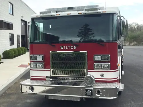 Head-on front view showing grille, windshield, roof warning lights, and front bumper intakes.
