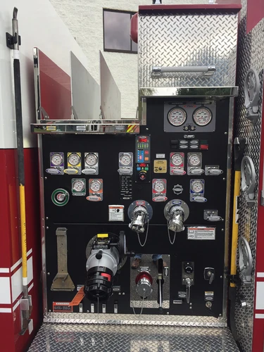 Close-up of the pump panel with gauges, intake controls, valves, and hose connections.
