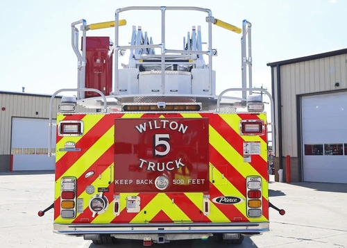 Rear view showing red-and-yellow chevrons and bucket platform at ladder tip