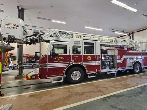 Tower ladder truck driver-side profile view showing aerial ladder and side body