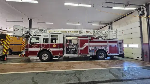 Wide bay view showing tower ladder truck parked with side profile visible