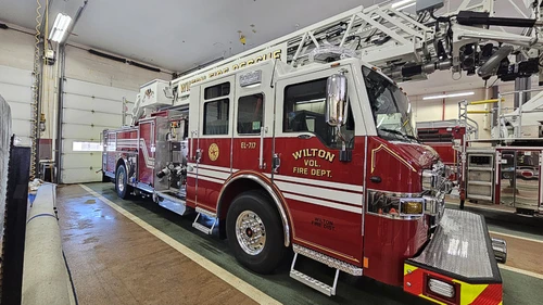 Driver-side profile view showing ladder bed and tandem rear wheels