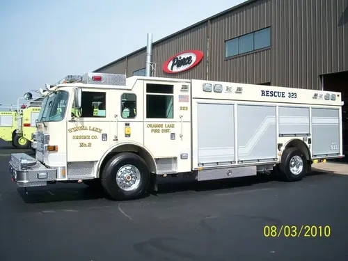 Driver-side profile of a rescue truck with enclosed cab, long side compartments, and rear wheel area.