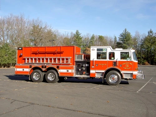 Officer-side profile showing tanker body compartments, pump panel section, and tandem rear wheel area.