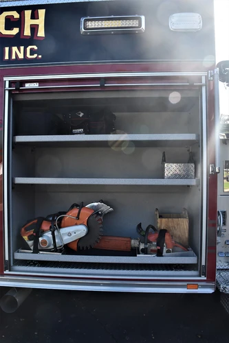 Open side compartment showing shelf storage with saws and equipment