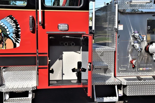 Driver-side mid-body view showing open panel near pump controls