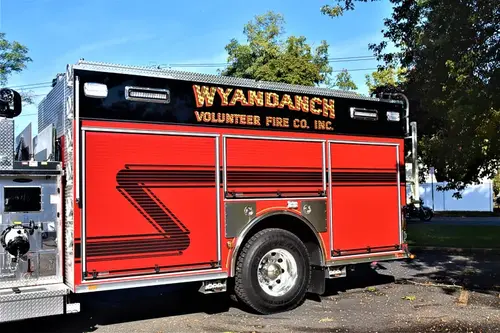 Driver-side profile view showing pumper body and rear wheel area