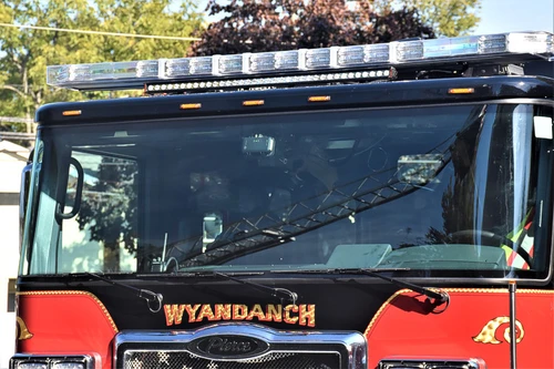 Front-right cab close-up showing windshield, mirror, and crest badge