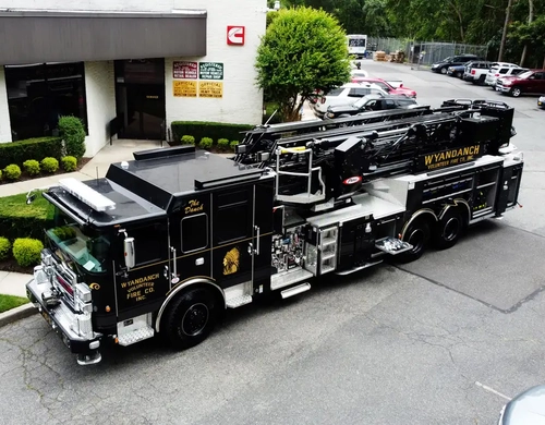 Aerial ladder truck front-left exterior view showing black cab and front bumper