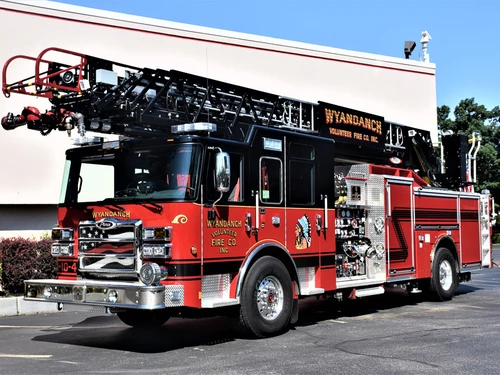 Aerial ladder truck front-left exterior view showing black ladder beam and cab