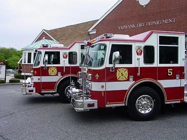 Front-right lineup close view showing the cabs and front bumper sections of both pumpers.
