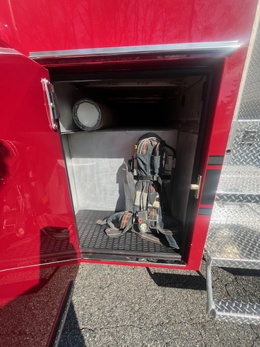 Rear view showing chevron striping, hosebed opening, and rear hose connections