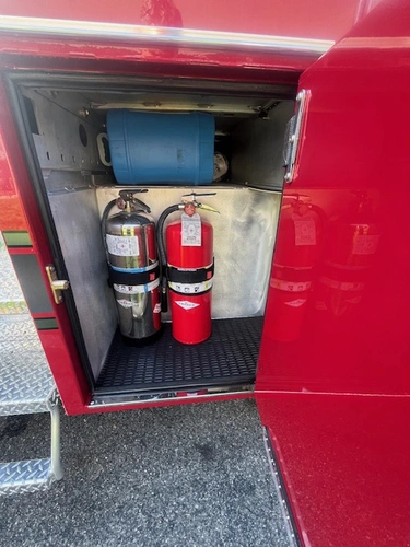 Open side compartment with fire extinguishers and utility storage