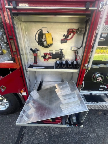 Open side compartment above rear wheel with slide-out tray and equipment storage