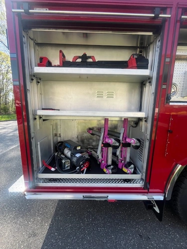 Open side compartment showing stabilizing struts and extrication tools on pull-out tray