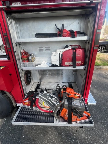 Open side compartment showing chainsaws, saw blades, and rescue saw storage