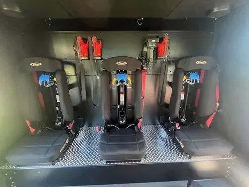 Rear crew compartment interior close-up showing fold-down seats and SCBA mounts